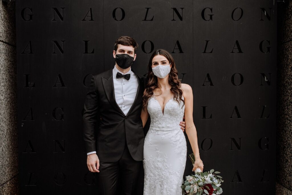 A wedding couple wearing masks.